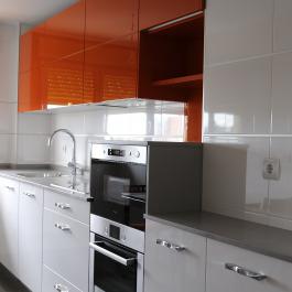 Buscamos aquí un contraste entre los muebles bajos e color blanco y los superiores en color mandarina para dar viveza a la estancia